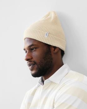 A close up of a man wearing a off whire Province of Canada button up shirt and beanie