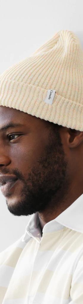 A close up of a man wearing a off whire Province of Canada button up shirt and beanie
