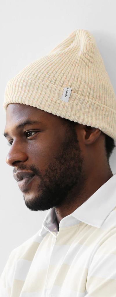 A close up of a man wearing a off whire Province of Canada button up shirt and beanie