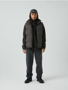 A man with dreads wearing a grey puffy Mads Norgaard vest and a matching hoodie, pants and hat.