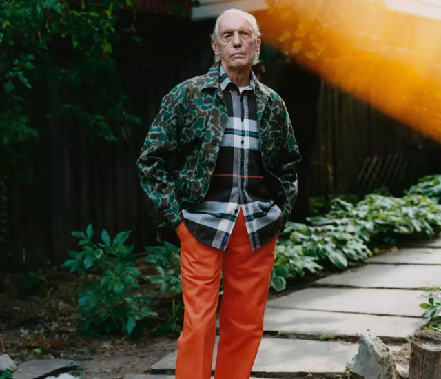 An older man wearing a camo print Noah jacket and orange pants