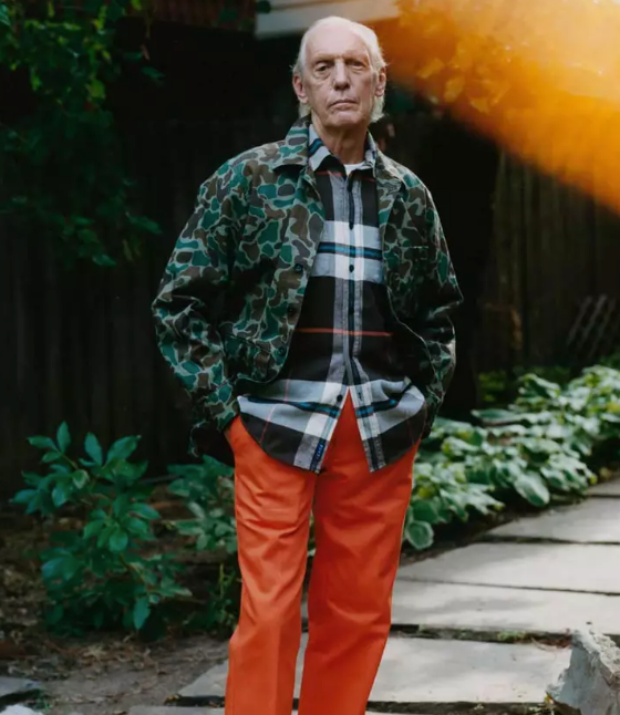 An older man wearing a camo print Noah jacket and orange pants