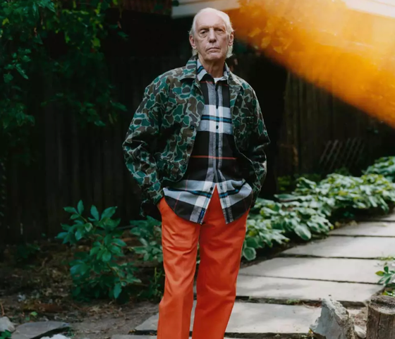 An older man wearing a camo print Noah jacket and orange pants
