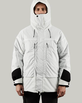 A man in a photoshoot setting wearing a white futuristic looking Vollebak Jacket