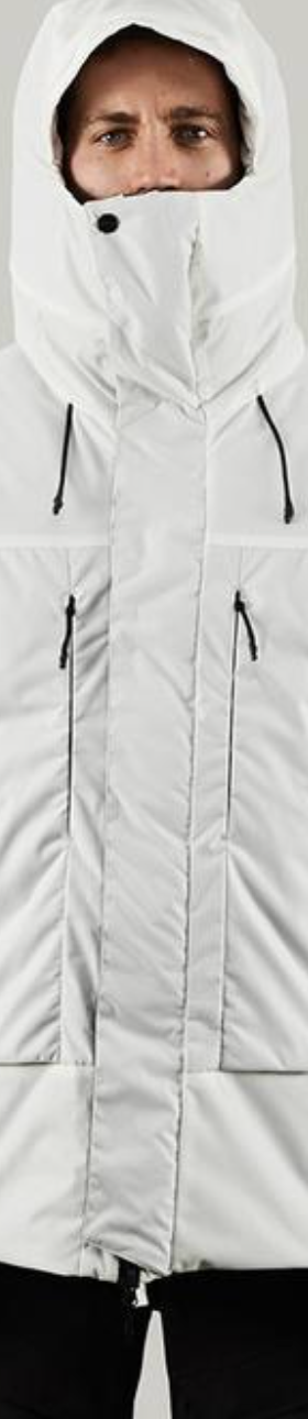 A man in a photoshoot setting wearing a white futuristic looking Vollebak Jacket