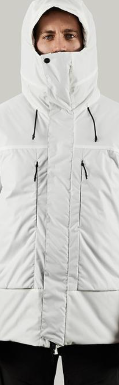 A man in a photoshoot setting wearing a white futuristic looking Vollebak Jacket