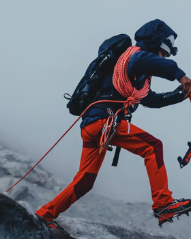 A man doing a high intensity trek on ice with heavy duty Mammut apparel and hiking gear