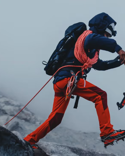 A man doing a high intensity trek on ice with heavy duty Mammut apparel and hiking gear