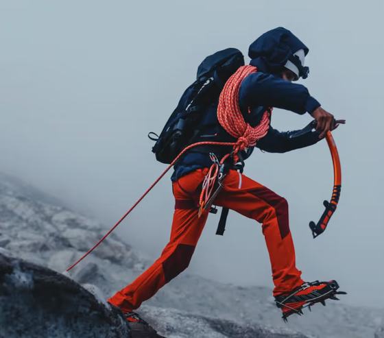 A man doing a high intensity trek on ice with heavy duty Mammut apparel and hiking gear