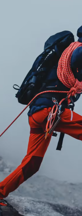 A man doing a high intensity trek on ice with heavy duty Mammut apparel and hiking gear