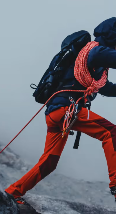 A man doing a high intensity trek on ice with heavy duty Mammut apparel and hiking gear