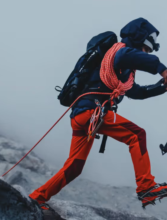 A man doing a high intensity trek on ice with heavy duty Mammut apparel and hiking gear