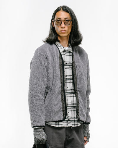 a man wearing a Haven grey fleece with a checkered button up and grey gloves