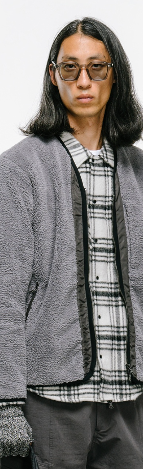 a man wearing a Haven grey fleece with a checkered button up and grey gloves