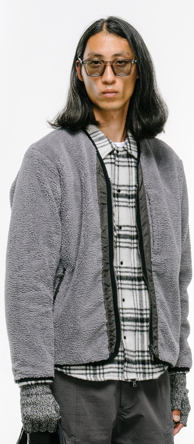 a man wearing a Haven grey fleece with a checkered button up and grey gloves