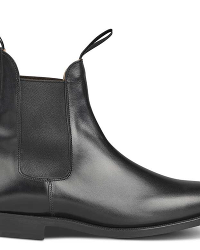 A black pair of handmade Trickers boots that look similar to Blundstones