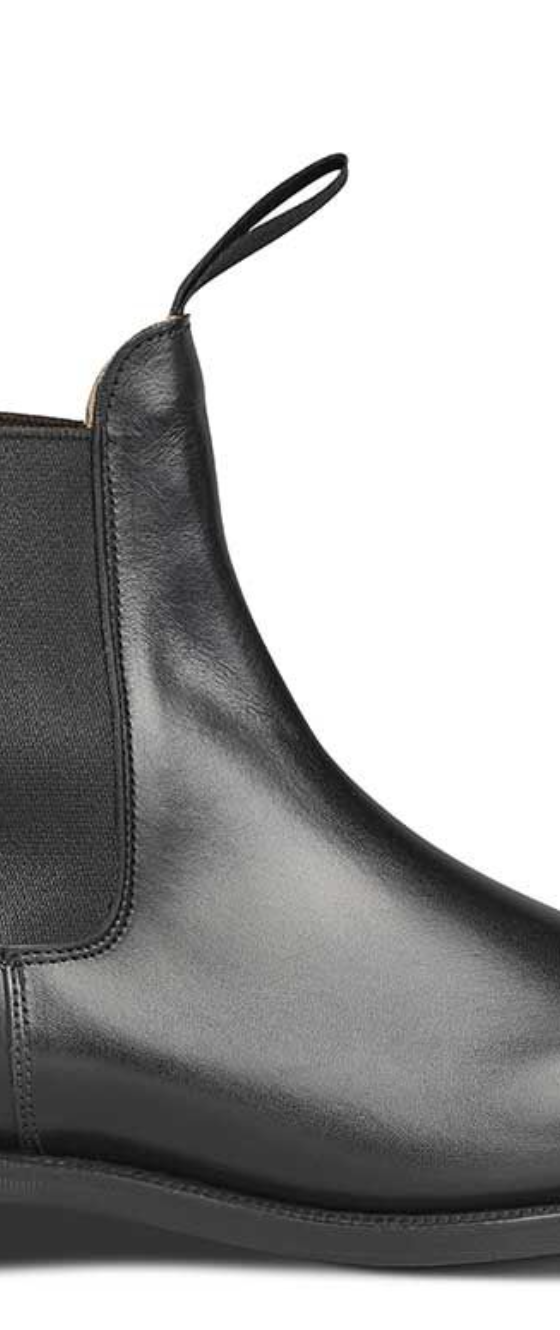 A black pair of handmade Trickers boots that look similar to Blundstones