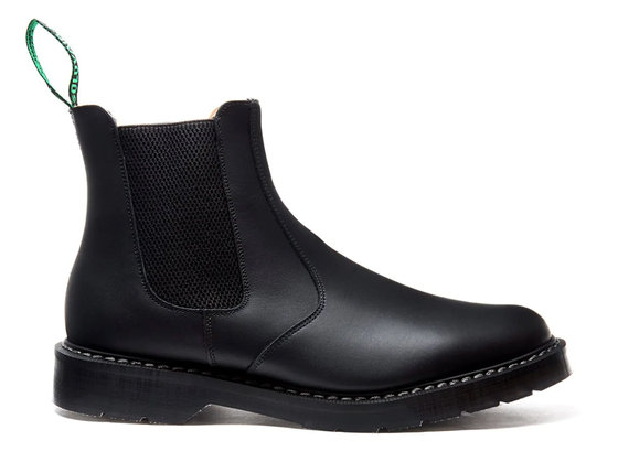 A black pair of Solovair boots that look similar to Blundstones on a white backgorund