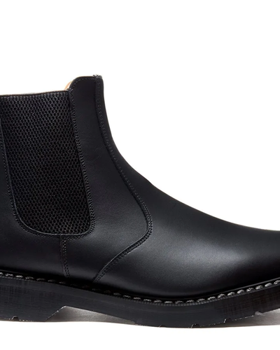 A black pair of Solovair boots that look similar to Blundstones on a white backgorund