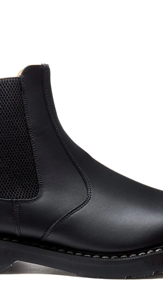 A black pair of Solovair boots that look similar to Blundstones on a white backgorund