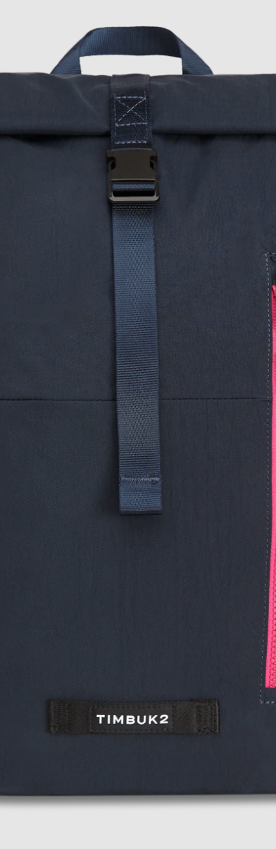 A black Timbuk2 backpack with a red zipper on a white background