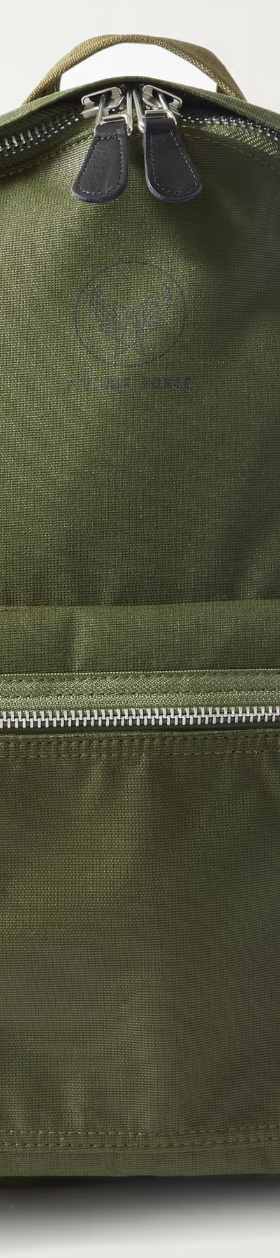 A dark green Porter Yoshida backpack with a silver zipper on a white background