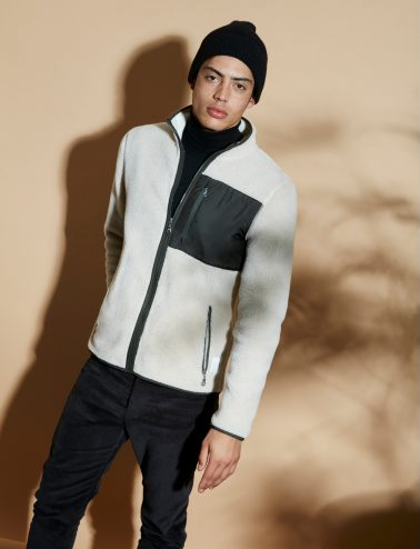 A man wearing a ArmedAngles fleece with a black beanie