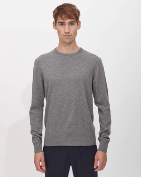 A man wearing a SANVT grey long-sleeve and dark navy blue pants