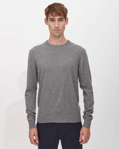 A man wearing a SANVT grey long-sleeve and dark navy blue pants