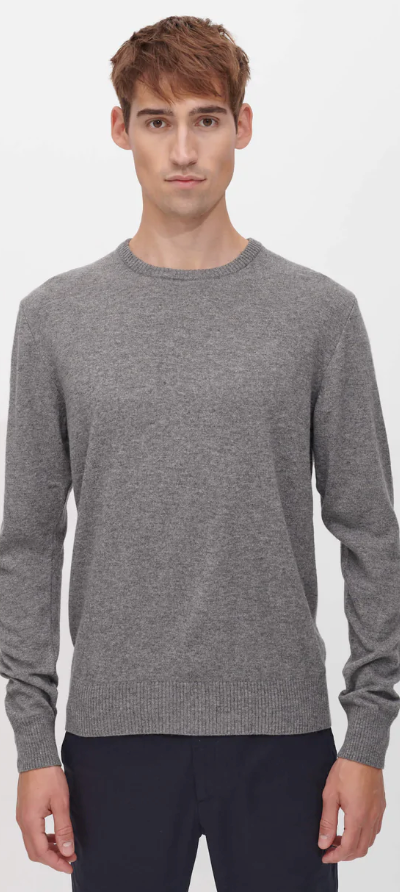 A man wearing a SANVT grey long-sleeve and dark navy blue pants