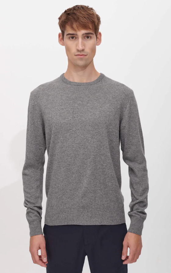 A man wearing a SANVT grey long-sleeve and dark navy blue pants