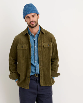 A man wearing a Alex Mill oliver green button up with a blue beanie and navy blue pants