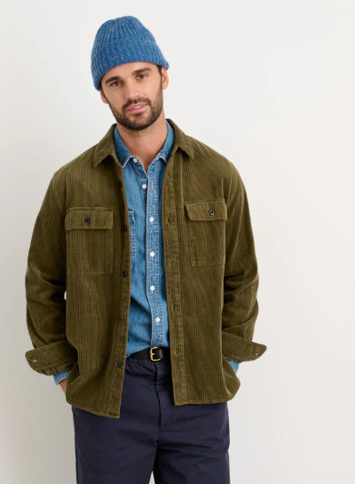 A man wearing a Alex Mill oliver green button up with a blue beanie and navy blue pants