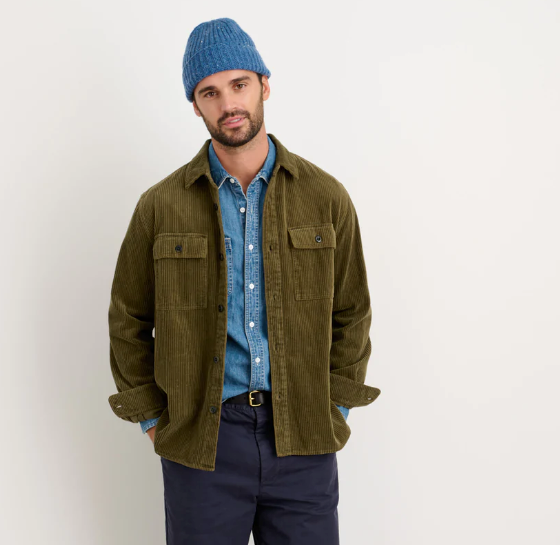 A man wearing a Alex Mill oliver green button up with a blue beanie and navy blue pants