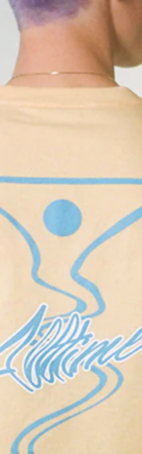 A man wearing a peach and light blue All-timers t-shirt with a martini graphic on it