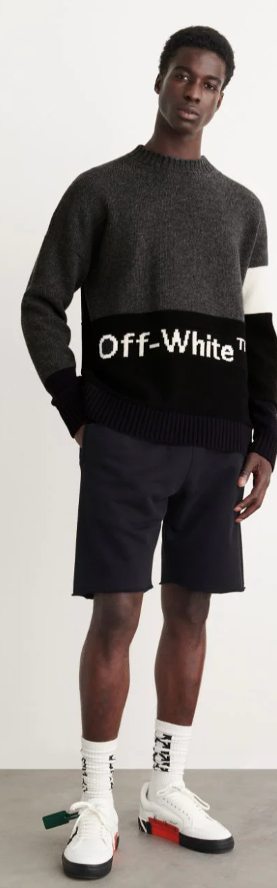 A man wearing a black Off-White sweater, black shorts and branded Off-white socks