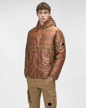 A man wearing a CP Company red and brown technical jacket and brown pants