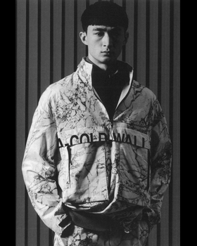 A man wearing a camo-styled A-COLD-WALL jacket with matching pants and a black fleece underneath