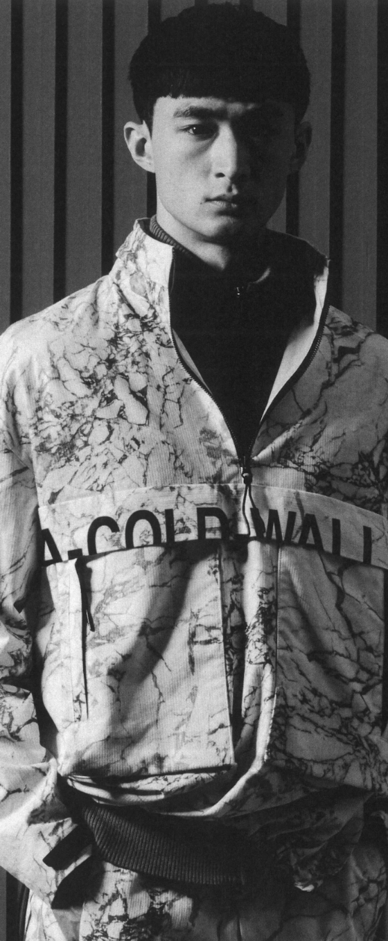 A man wearing a camo-styled A-COLD-WALL jacket with matching pants and a black fleece underneath