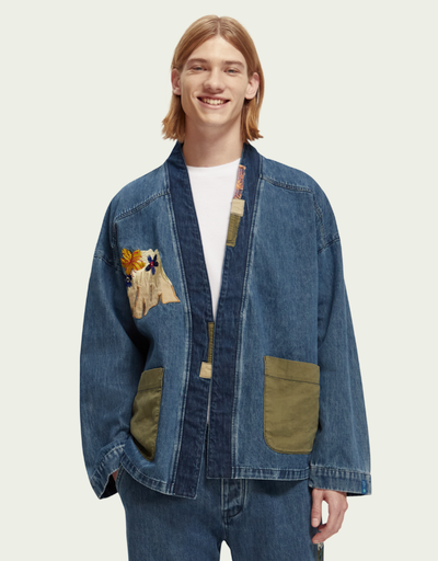 A man wearing a Scotch & Soda Japanese style denim jacket and matching pants with floral designs sewn on