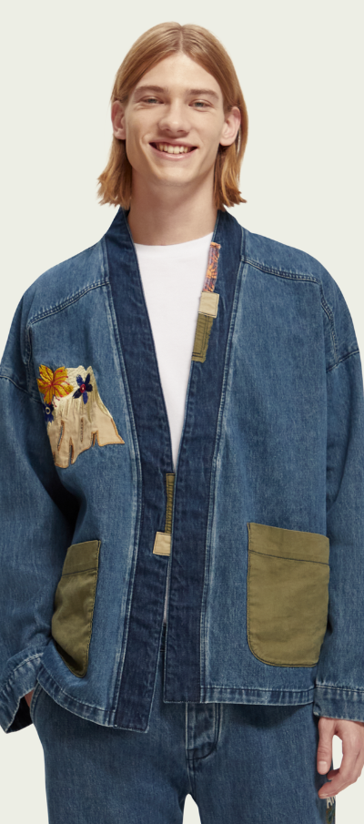 A man wearing a Scotch & Soda Japanese style denim jacket and matching pants with floral designs sewn on