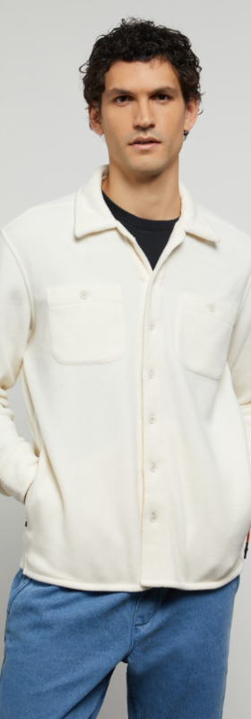 A man wearing a plush Onia button-up with a black shirt underneath and blue-washed jeans