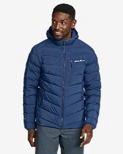 A man wearing a navy blue Eddie Bauer down a jacket with jeans
