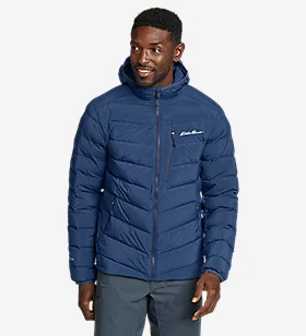 A man wearing a navy blue Eddie Bauer down a jacket with jeans