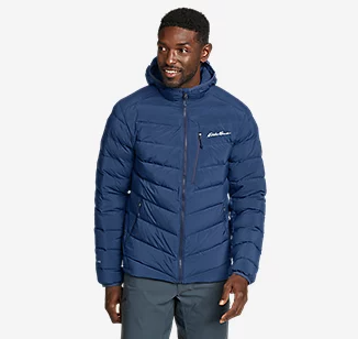 A man wearing a navy blue Eddie Bauer down a jacket with jeans