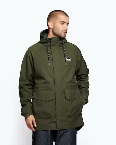A man wearing a dark green Penfield winter jacket with dark jeans
