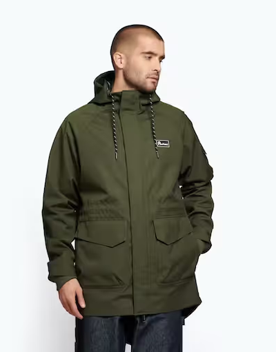 A man wearing a dark green Penfield winter jacket with dark jeans