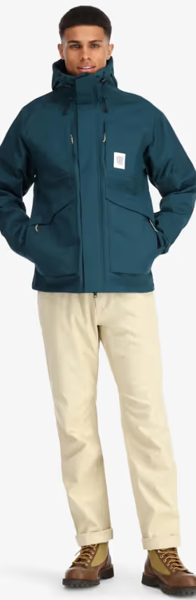 A man wearing a Teal Topo Designs Winter Jacket with Khaki pants and Danner boots