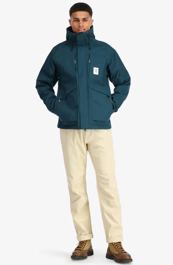 A man wearing a Teal Topo Designs Winter Jacket with Khaki pants and Danner boots