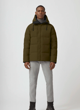 A man wearing an olive Canada Goose down jacket and grey pants